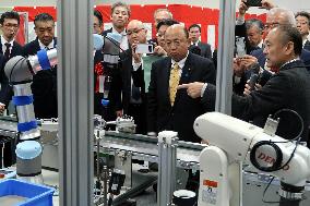 People involved in the Tottori Robot Hub receive an explanation of the simulated production line.