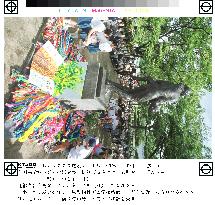 Children offer paper cranes to Hiroshima's monument