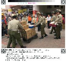 Relief supplies arrive near crumbled hotel