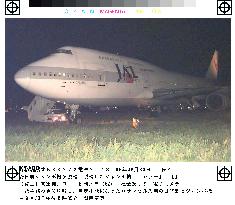 JAL jumbo gets stuck in grass at Kansai airport
