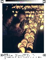 Family gazes at bamboo lanterns lit to mourn war dead