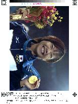 Japan's marathon runner Takahashi smiles with gold medal, bouque