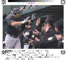 May greeted by teammates after homer against Seibu