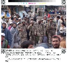 Northern Alliance soldiers walk in Kabul market