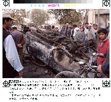 Residents look at wrecked Taliban vehicle