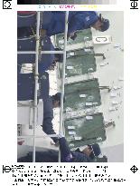 Police officers check bullet holes on patrol boat