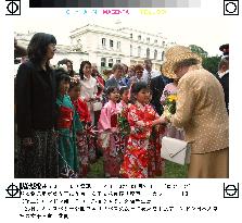 Kimono-clad Japanese girls present flowers to Queen Elizabeth