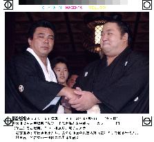 Nagoya sumo winner Chiyotaikai shakes hands with stable master