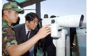 LDP's Abe peers through binoculars at N. Korea