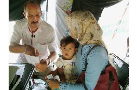 Cuban doctor examines child in Indonesia