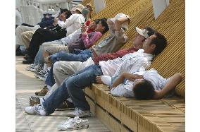 Visitors rest under summer-like weather at Aichi Expo