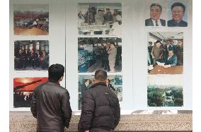 People look at photos of Kim Jong Il at N. Korean Embassy