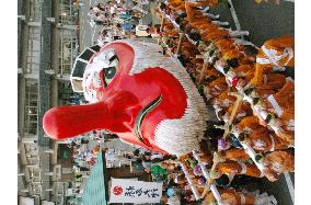 Women carry giant mask of Japanese long-nose goblin in festival