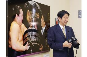 Abe attends news photography show