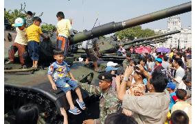 Children play on tanks deployed in Bangkok
