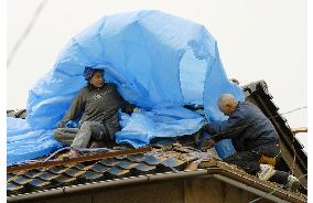 Noto earthquake - Covering damaged roof with vinyl sheet as bad weather approches