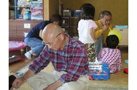 Retired people helping out children at daycare facilities