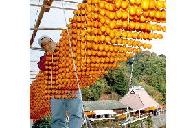 Persimmons, a good-luck talisman, being prepared for New Year season
