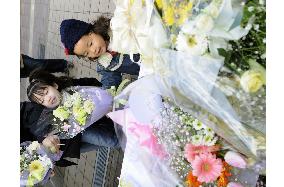 Children lay flowers at scene of shooting rampage in Sasebo