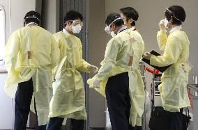 Quarantine officers check passengers arriving at Narita for flu