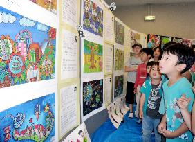 Japan children look at pictures from quake-hit Sichuan Province
