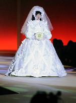 Humanoid model walks on catwalk in wedding gown