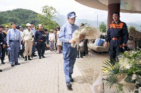 Aso offers flowers for mudslide victims at nursing home