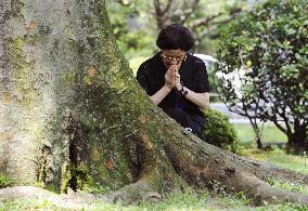 Woman prays on WWII memorial in Japan