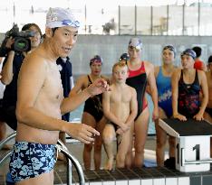 Olympic medalist Suzuki instructs children at swimming event