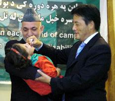 Okada gives Afghan child polio vaccine