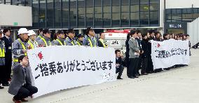 JAL employees distribute messages cards promising recovery