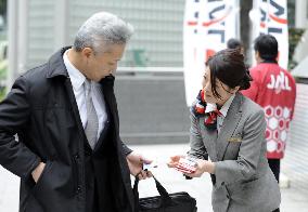 JAL employees distribute messages cards promising recovery