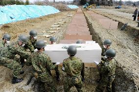 Burial of quake and tsunami victims