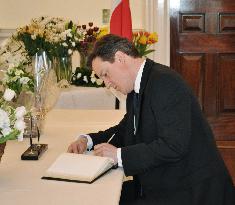 Cameron signs condolence book