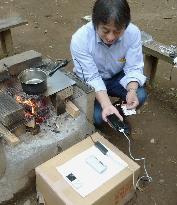 Charging cellphones with heat from open fire