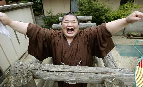 Sumo wrestler smiles broadly after promotion