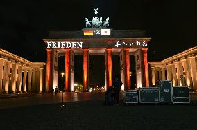 Words meaning 'peace' projected onto Brandenburg Gate