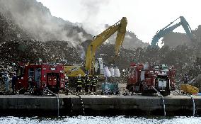 Debris from March disaster catches fire