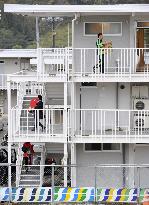 People moving into three-story temporary housing complex