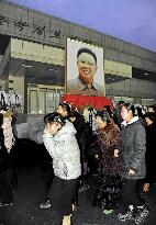 Citizens mourn before Kim's portrait