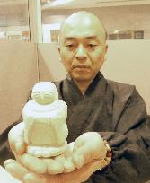 Buddhist monk with jizo deity statue
