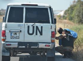 U.N. vehicles with monitors fired at near Syria massacre site