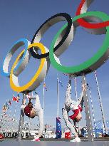 Performers pose under Olympic rings in Sochi