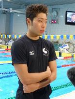 Hagino talks to reporters during swim training