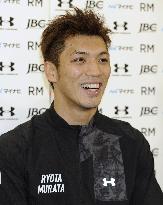 Murata smiles as he meets press in Tokyo