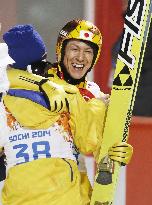Japan's Kasai hugs teammate after winning large hill silver
