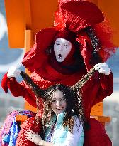 Street performer plays with visitor's hair at Olympic Park