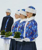 Russian women hold ceremonial flowers for Sochi medalists