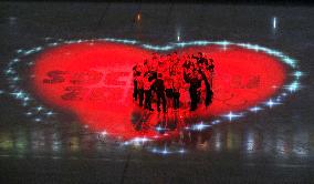 Figure skaters gather in heart-shaped illumination