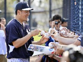 Yankees' rookie pitcher Tanaka signs autographs at camp